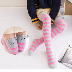 Détail de la texture en polaire corail et broderie chat sur chaussettes rayées