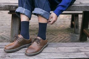 Detail of wool socks worn with brown leather lace-up shoes and yellow contrast stitching