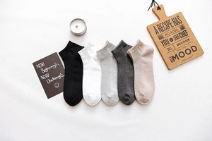 Flat lay of five pairs of men's cotton low-cut liner socks in neutral solid colors