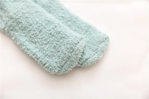 Close-up of soft mint green coral fleece fabric texture on these warm thermal socks
