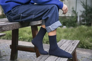 Detail of navy blue ribbed wool business socks for men worn in an outdoor setting