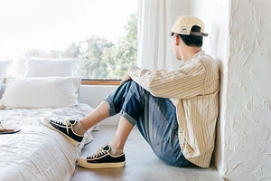 Lifestyle shot of black low-top canvas sneakers with blue jeans and cotton boat socks