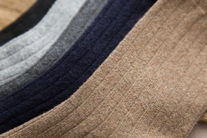 Detail of multi-color ribbed wool socks in black, grey, navy, and oatmeal on wood