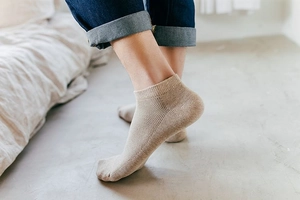Close-up of men's breathable khaki mesh loafer socks paired with blue jeans