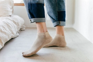 Close-up of beige low-cut ankle socks featuring breathable mesh texture and elastic rib cuff