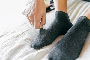 Detail of dark grey mesh ankle sock showing high elasticity and breathable fabric texture