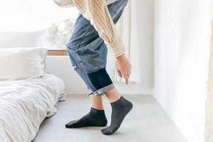 Detail of dark grey low-cut cotton ankle socks with breathable mesh and ribbed cuffs