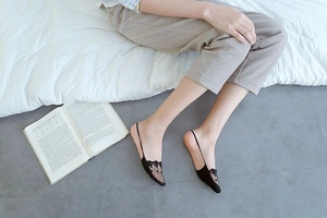 Detail of low-cut black lace no-show socks with a 3D floral pattern on a model feet