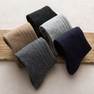 Five pairs of thick winter wool socks for men in classic colors with ribbed knit texture