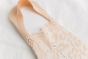 Detailed close-up of beige floral lace no-show socks with silicone anti-slip grip edge