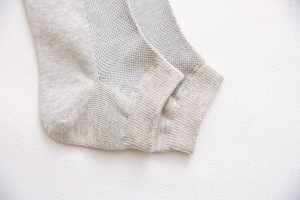 Close-up of gray cotton knit socks showing fine ribbed texture and elastic cuff detail