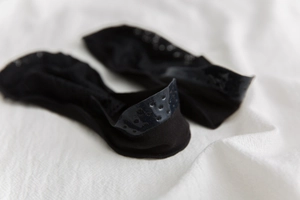 Close-up of black lace no-show socks featuring anti-slip silicone dots on the heel