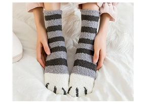 Détail de chaussettes en polaire corail à rayures grises et motifs de pattes de chat