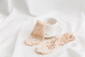 Detail of peach lace trim socks hanging on a ceramic cup with a soft aesthetic vibe