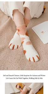 Detail of warm coral fleece cat paw socks with plush texture and cute pattern