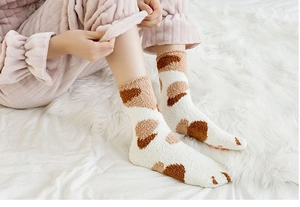 Gros plan de chaussettes chat en polaire corail montrant la texture et l'antidérapant