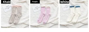 Close-up of thick coral fleece socks in khaki, purple, and white with cable knit texture