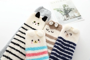 Détail de chaussettes rayées en polaire corail avec oreilles d'animaux 3D et broderies