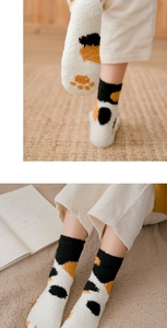 Detailed view of thick coral fleece socks with cute cat paw patterns and fuzzy texture