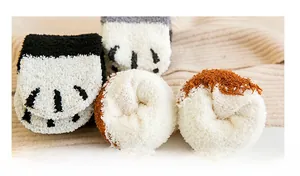 Gros plan de chaussettes de sommeil épaisses en molleton corail avec motifs de pattes de chat