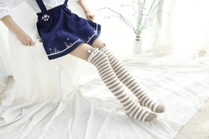 Détail de chaussettes hautes rayées en polaire corail avec décorations d'oreilles 3D