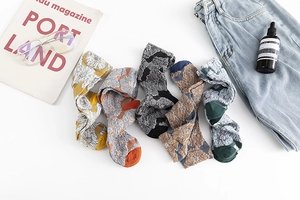 Flat lay of five vintage floral knit socks with 3D jacquard textures for autumn and winter
