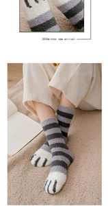 Close-up of thick grey striped coral fleece socks with cute cat paw embroidery and texture