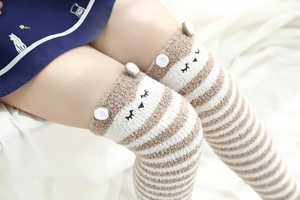 Détail de chaussettes hautes rayées en polaire corail avec broderie d'oreilles d'ours