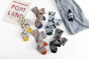 Detailed view of five pairs of vintage floral patterned cotton socks in various warm colors