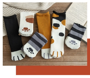 Detailed view of five pairs of warm cotton socks with creative cat paw patterns and rolled edges