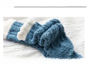 Close-up of thick blue coral fleece socks with white faux shearling trim and ribbed texture