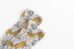 Detail shot of vintage ginger and grey socks with embossed floral knit texture