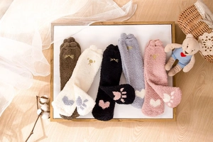 Flat lay of five pairs of colorful coral fleece socks with cute cat paw embroidery