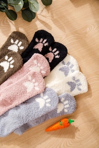Close-up of thick coral fleece winter socks with cute cat paw patterns in multiple colors