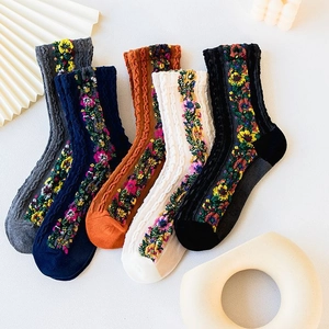 Detail of five vintage knit socks with colorful floral patterns and ribbed cotton texture