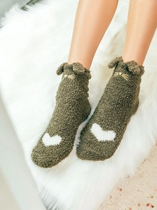 Close-up of olive green coral fleece socks with cat ear detail and heart embroidery
