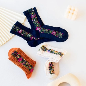 Detailed embroidery on ribbed knit cotton socks in navy blue, orange, and beige tones