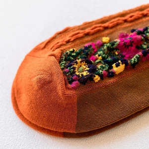 Detail of cable knit pattern and floral embroidery on warm cotton winter crew socks
