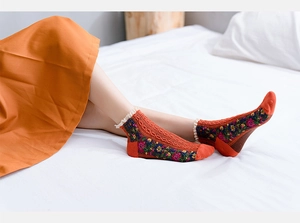 Detail showing vintage bohemian cotton socks with lace trim and knit texture in warm orange