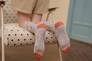 Detailed close-up of retro floral pattern jacquard socks with orange contrast toe and heel