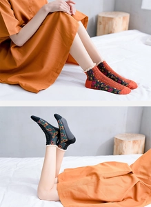 Close-up of floral cotton socks with lace trim in vintage orange and charcoal grey colors
