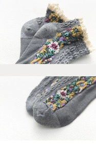 Detail of grey cotton socks featuring vintage floral embroidery and white lace trim edge