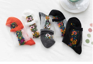 Mise à plat de chaussettes en résille transparente avec broderie florale multicolore