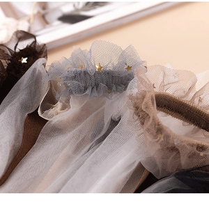 Close-up of sheer lace socks with delicate mesh ruffles and gold star sequins detail