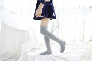 Gros plan de chaussettes hautes gris clair en polaire corail avec texture peluche