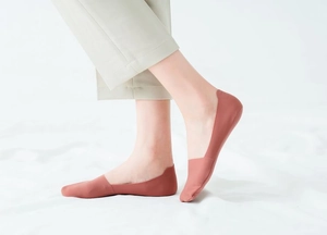 Close-up of caramel ice silk seamless no-show socks worn with casual trousers