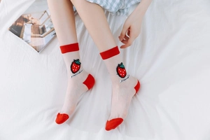 Detailed shot of strawberry patch on semi-transparent red and white mesh socks