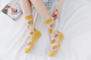 Detail of yellow mesh socks featuring cartoon lion patterns and vibrant polka dots