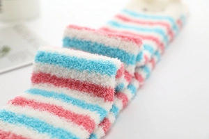 Détail de la texture douce en polaire corail épaisse sur ces chaussettes rayées d'hiver