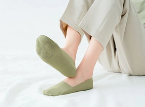 Detail of light green no-show sock with floral wreath and Socks text on the sole